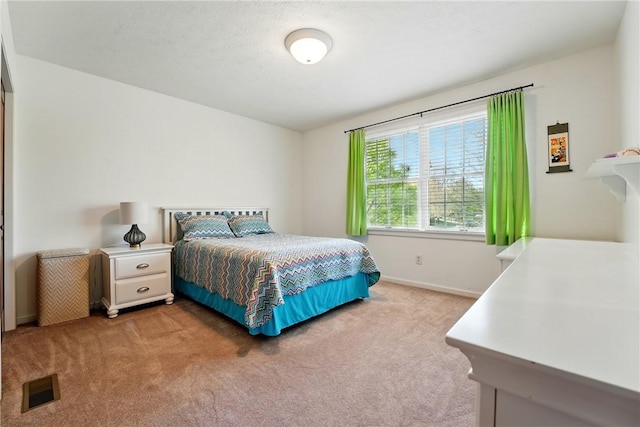 carpeted bedroom with baseboards and visible vents