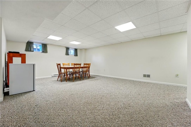 carpeted dining space with baseboards, a paneled ceiling, and visible vents