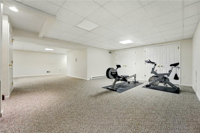 workout area with carpet floors, baseboards, and a paneled ceiling
