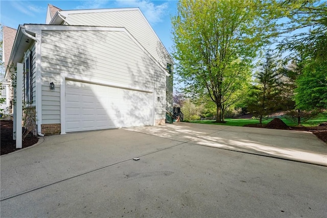 view of side of home with concrete driveway and a garage