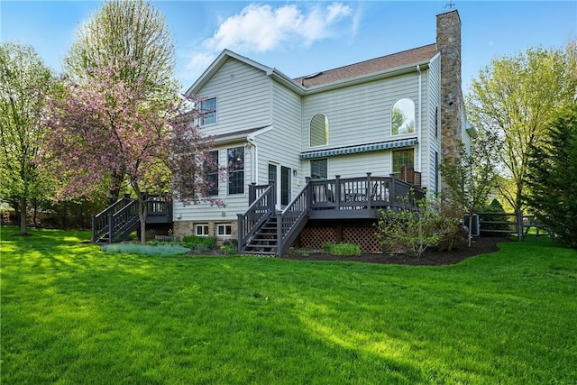 back of property featuring a chimney, a lawn, a wooden deck, fence, and stairs