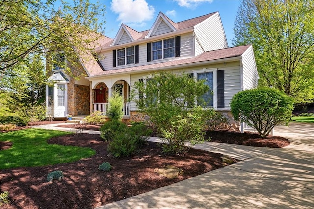 traditional-style home featuring a porch and stone siding