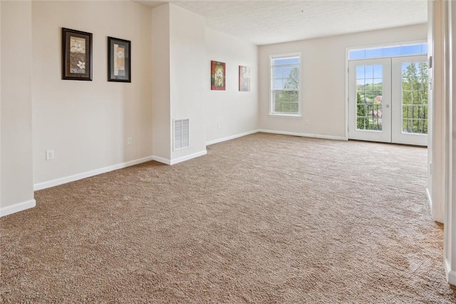 carpeted spare room with visible vents and baseboards
