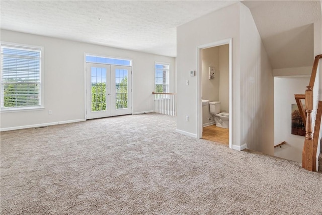 unfurnished living room featuring baseboards, carpet, french doors, and visible vents