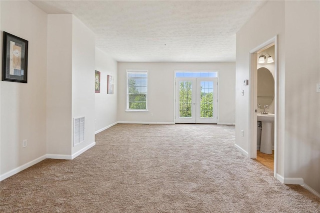 carpeted empty room with baseboards and visible vents