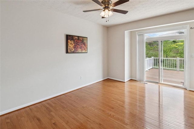 unfurnished room featuring baseboards, a ceiling fan, light wood finished floors, and a textured ceiling