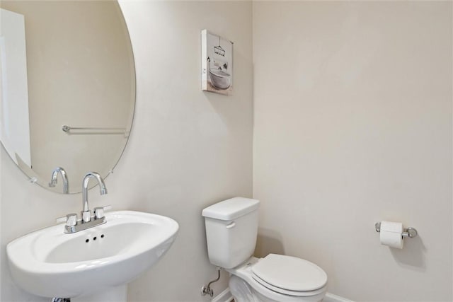 bathroom with a sink, baseboards, and toilet
