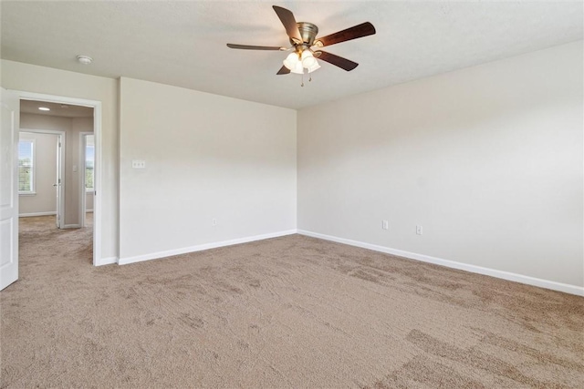 unfurnished room with baseboards, carpet flooring, and ceiling fan