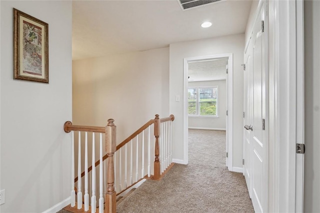 hall featuring visible vents, baseboards, an upstairs landing, carpet, and recessed lighting