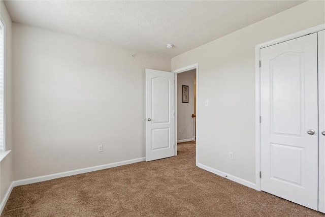 unfurnished bedroom featuring baseboards and carpet