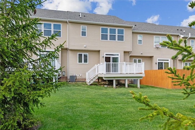 back of property featuring a lawn, central air condition unit, a wooden deck, and fence
