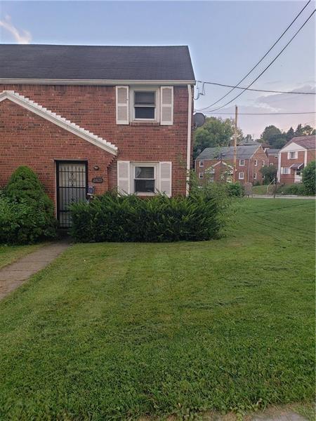 view of front of property featuring brick siding and a front yard