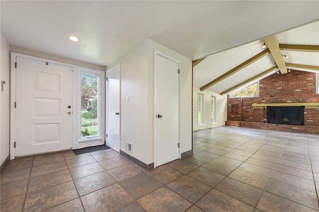 foyer entrance with a brick fireplace, recessed lighting, baseboards, vaulted ceiling with beams, and visible vents