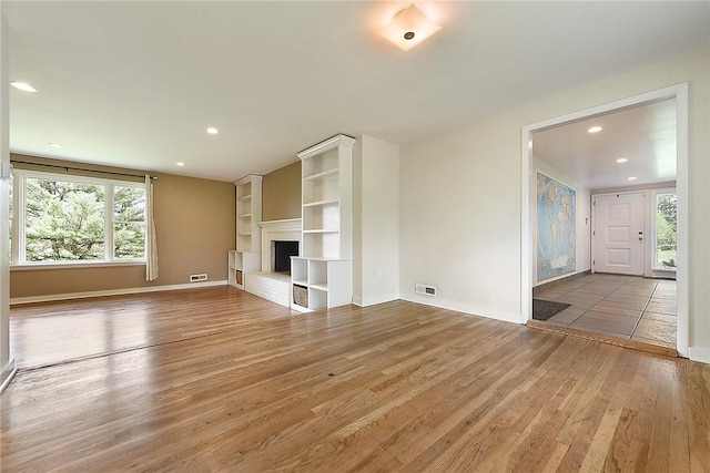 unfurnished living room featuring recessed lighting, visible vents, and hardwood / wood-style floors