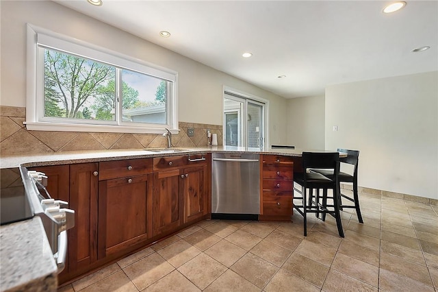 kitchen featuring a sink, dishwasher, recessed lighting, a peninsula, and backsplash