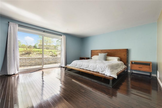 bedroom with access to outside and hardwood / wood-style floors
