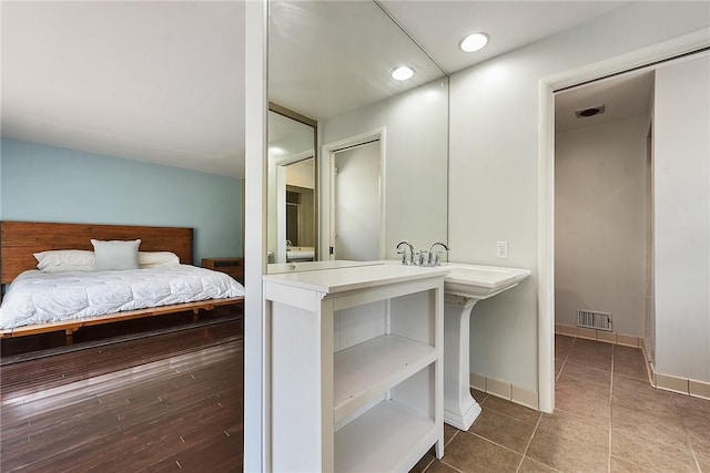 ensuite bathroom with recessed lighting, visible vents, a sink, and ensuite bath
