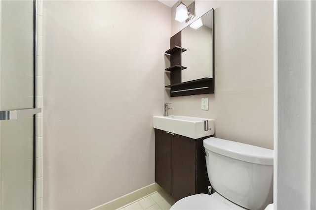 bathroom featuring vanity, baseboards, tile patterned flooring, and toilet