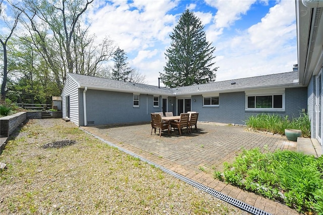 rear view of property featuring brick siding and a patio area