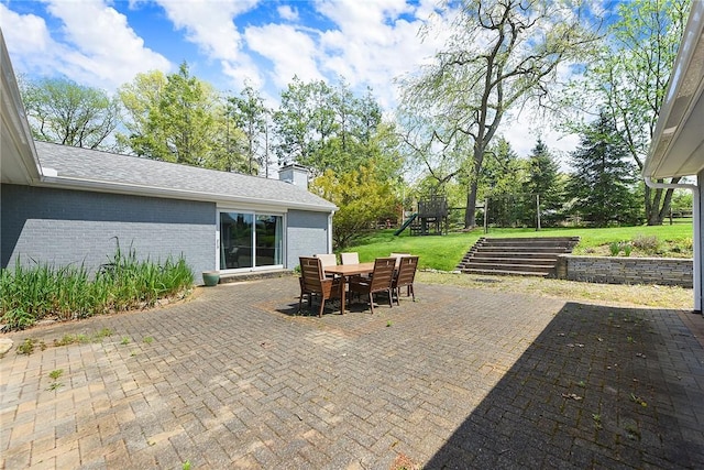 view of patio featuring a playground and outdoor dining area