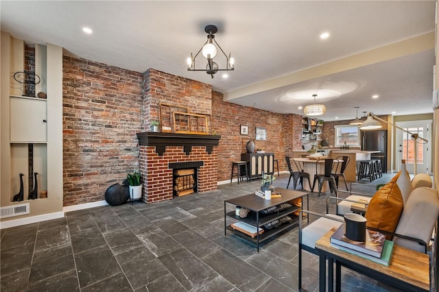 living room with baseboards, recessed lighting, marble finish flooring, a brick fireplace, and a chandelier