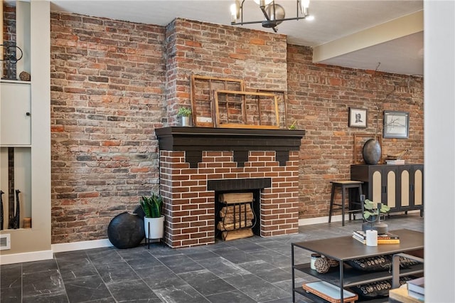 living room with baseboards, a fireplace, a chandelier, and brick wall