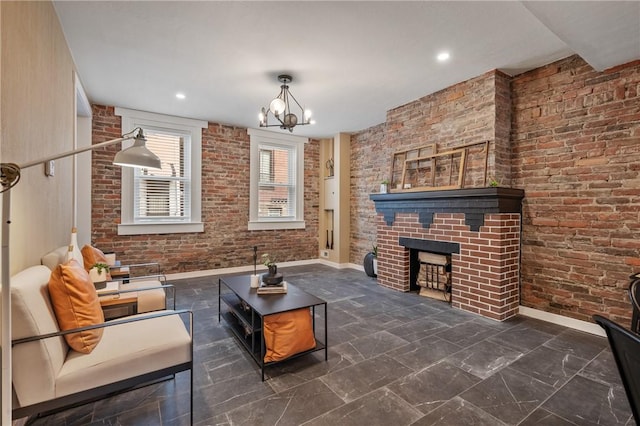 living room with a fireplace, a chandelier, baseboards, and brick wall