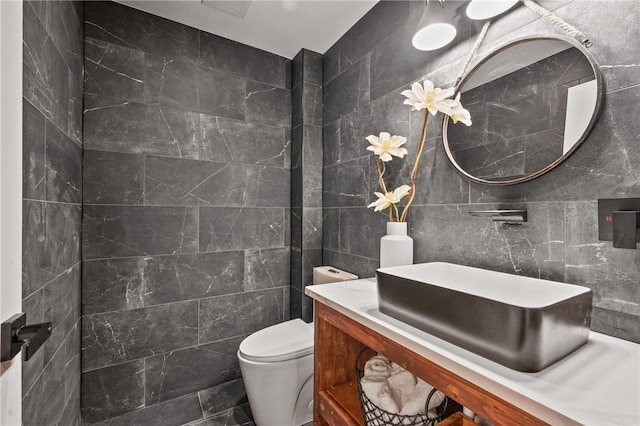 bathroom with tile walls, toilet, and vanity