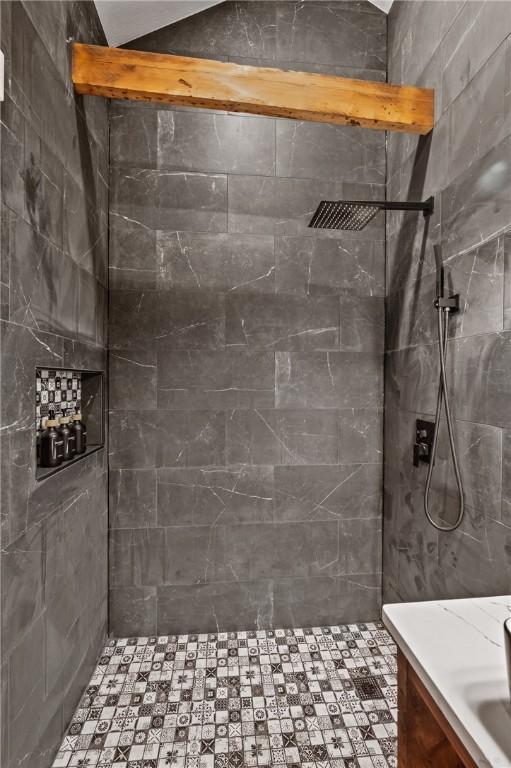 bathroom featuring a tile shower and vanity