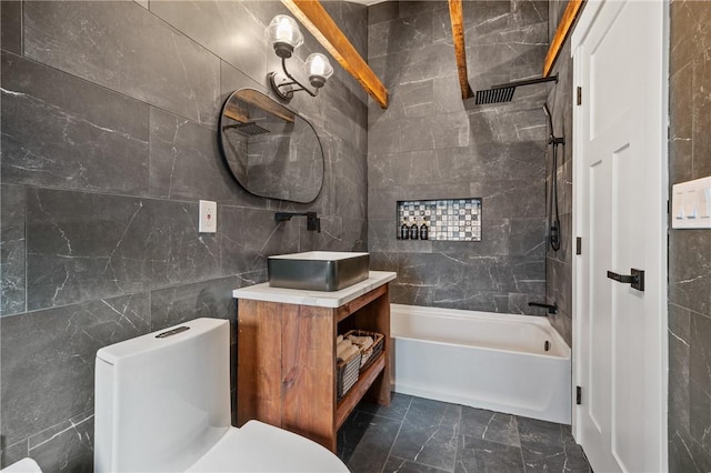 full bath featuring tile walls, washtub / shower combination, vanity, and toilet