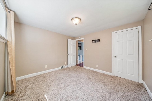 unfurnished bedroom featuring visible vents, baseboards, and carpet floors
