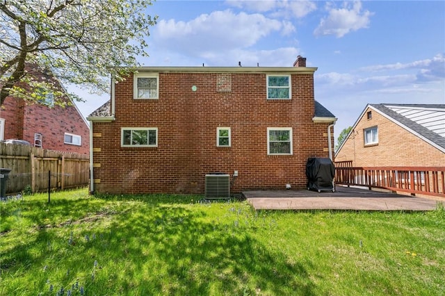 rear view of property with a patio area, central air condition unit, a yard, and a chimney