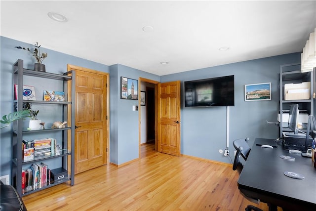 home office featuring baseboards and light wood finished floors