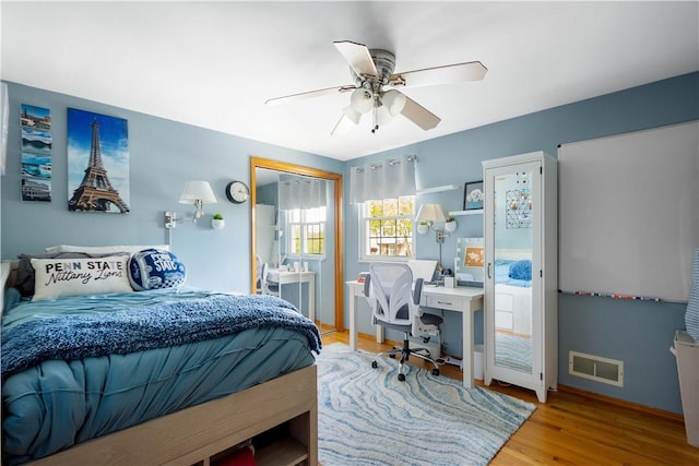 bedroom with baseboards, a ceiling fan, light wood-style flooring, and visible vents