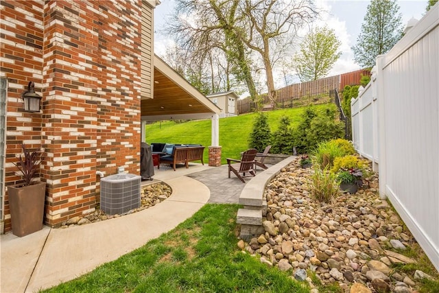 view of yard featuring a fenced backyard, an outdoor hangout area, cooling unit, and a patio area