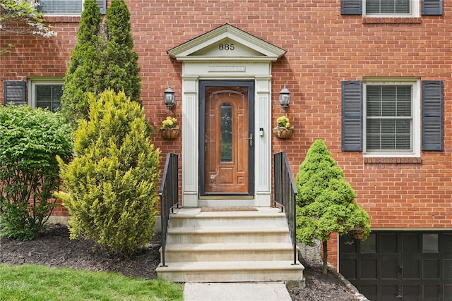 view of exterior entry featuring brick siding