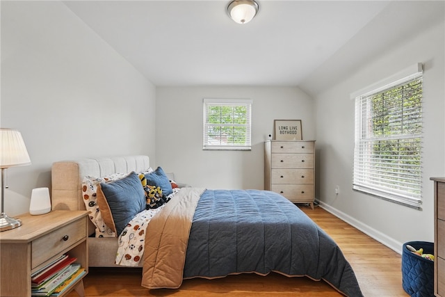 bedroom featuring baseboards, vaulted ceiling, and wood finished floors