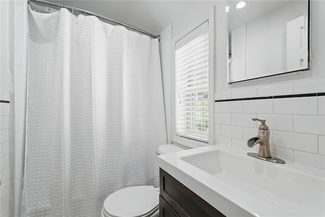 bathroom with toilet, tile walls, curtained shower, and vanity