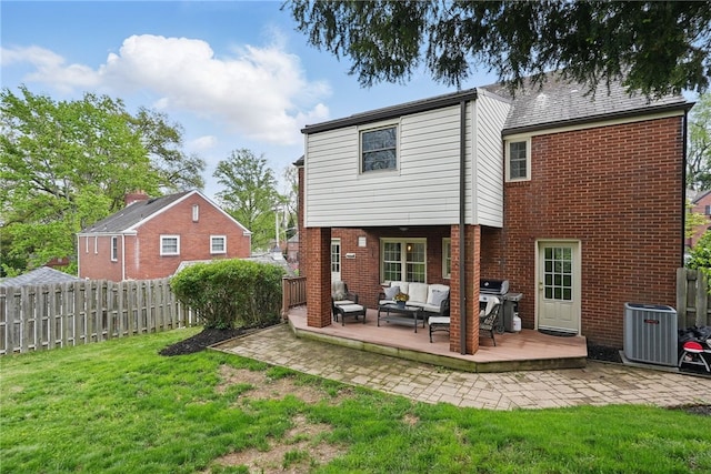 rear view of property featuring fence, a yard, an outdoor living space, and a deck