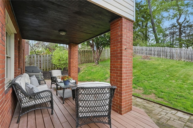 wooden deck featuring a fenced backyard, outdoor lounge area, and a yard