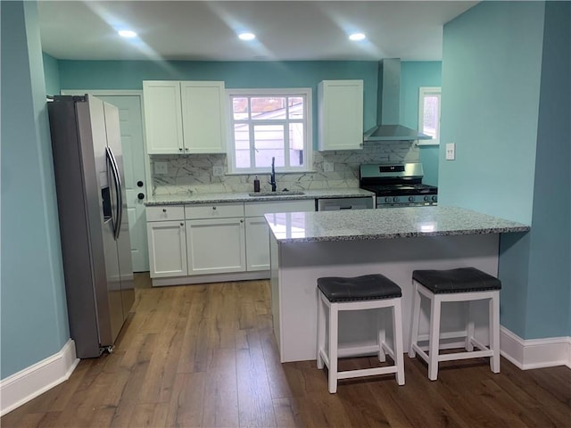 724 Maplewood Ave, Ambridge, PA 15003 - kitchen featuring stainless steel appliances, wall chimney exhaust hood, a sink, light stone countertops, and wood finished floors
