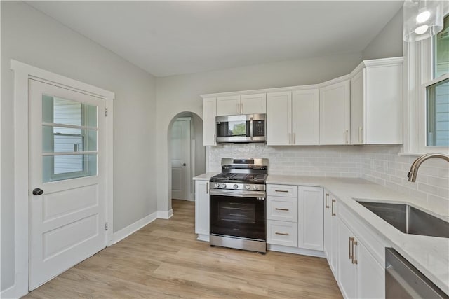 848 Ohio Ave, Monaca, PA 15061 - kitchen with white cabinets, stainless steel appliances, arched walkways, and a sink