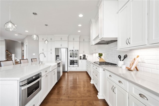 kitchen with decorative backsplash, a sink, stainless steel appliances, recessed lighting, and white cabinetry