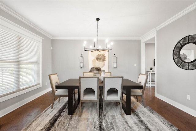 dining space featuring crown molding, baseboards, wood finished floors, and a notable chandelier