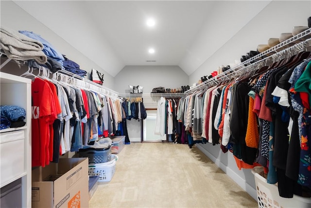 walk in closet with carpet flooring and vaulted ceiling