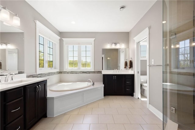 full bath featuring a garden tub, a sink, a stall shower, and toilet