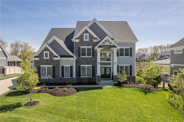 craftsman inspired home featuring a front lawn, board and batten siding, french doors, and stone siding