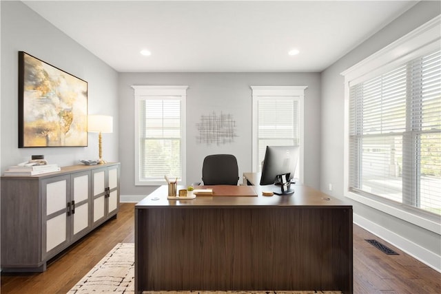 office space with baseboards, plenty of natural light, and dark wood-style flooring