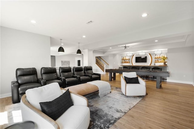 living room with stairs, recessed lighting, light wood-type flooring, a tray ceiling, and visible vents