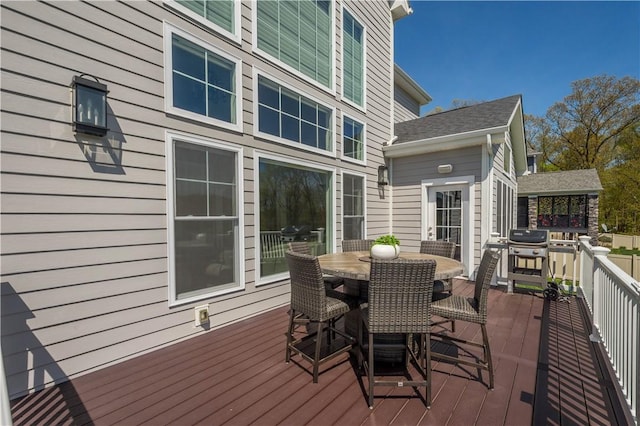 deck with outdoor dining space and a grill